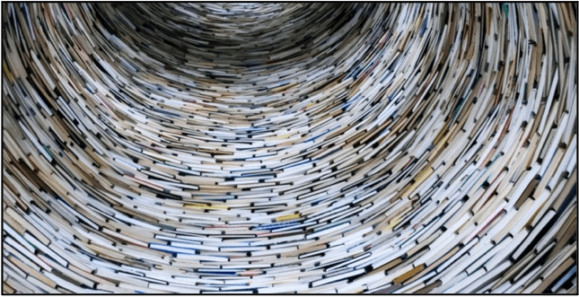 Trichter aus unzähligen dicht gestapelten Büchern, der sich in die Tiefe windet