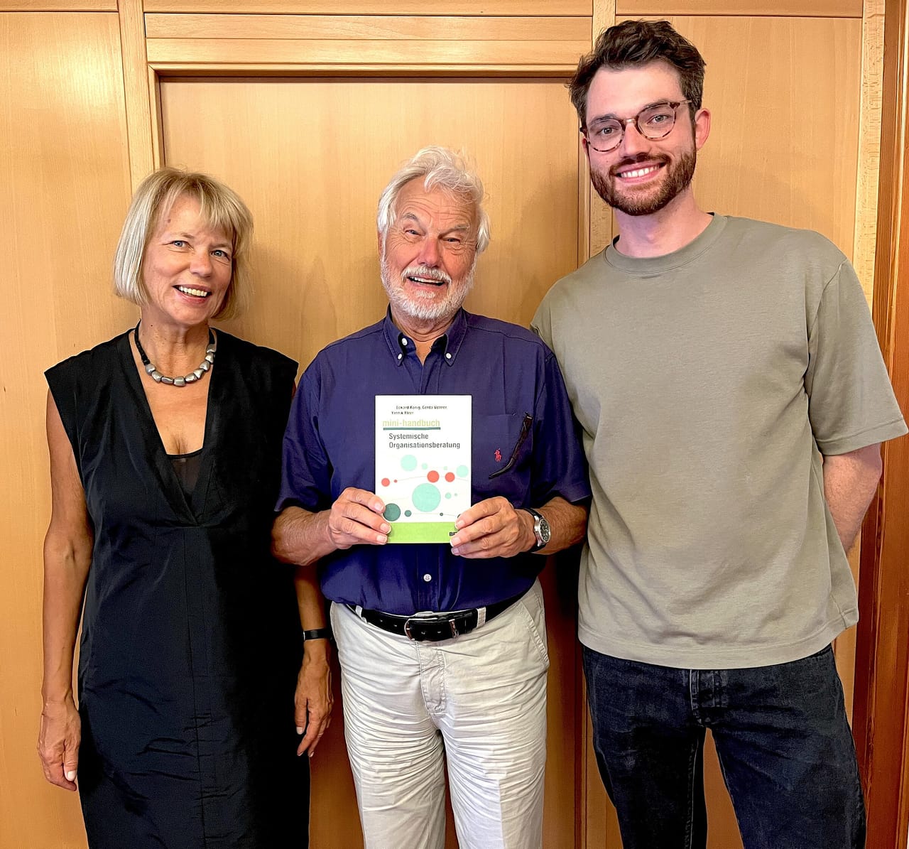 Gerda Volmer, Eckard König und Yannik Fleer mit dem Mini-Handbuch Systemische Organisationsberatung