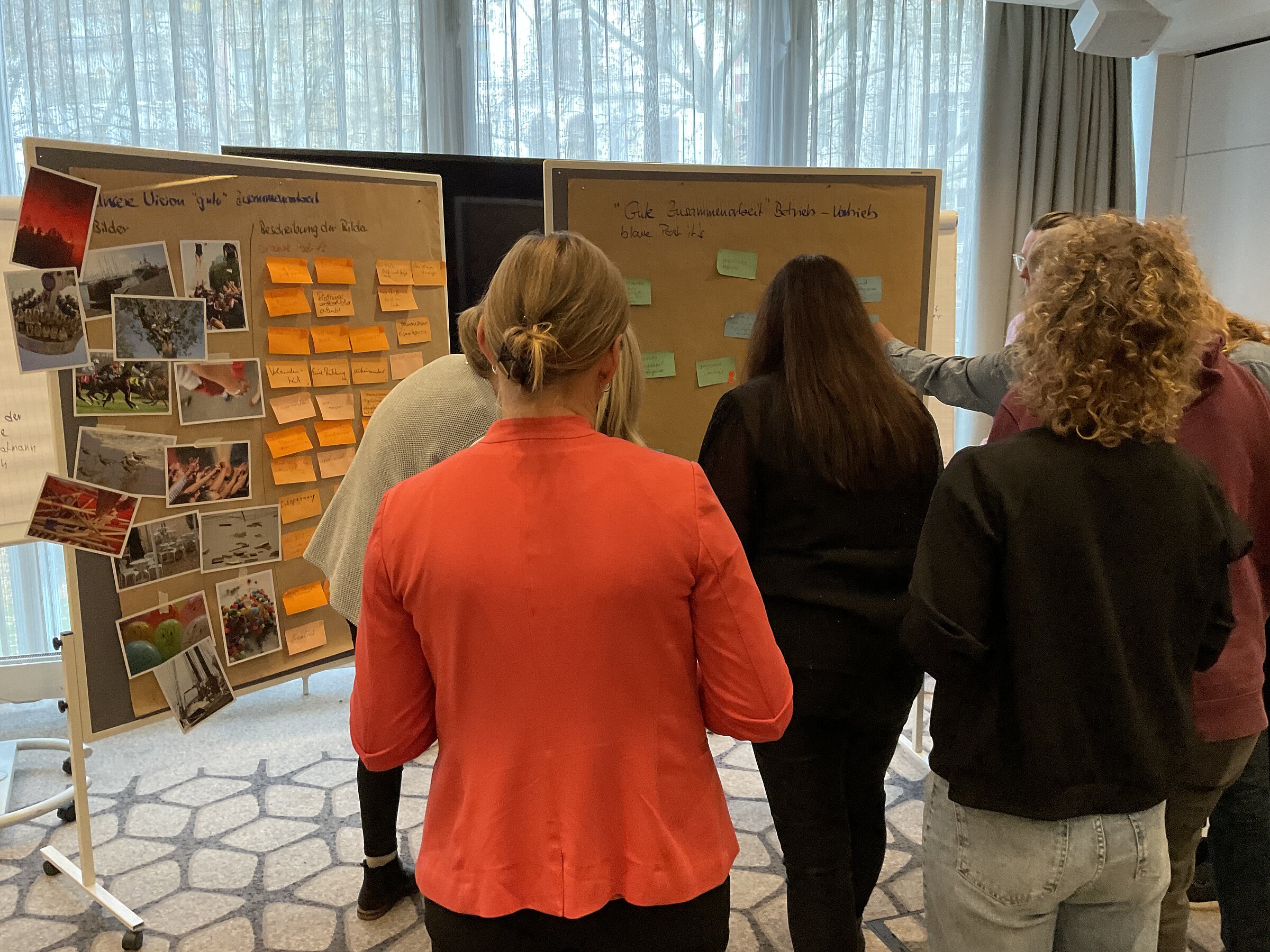 Teilnehmende des Workshops vor den beiden Pinnwänden